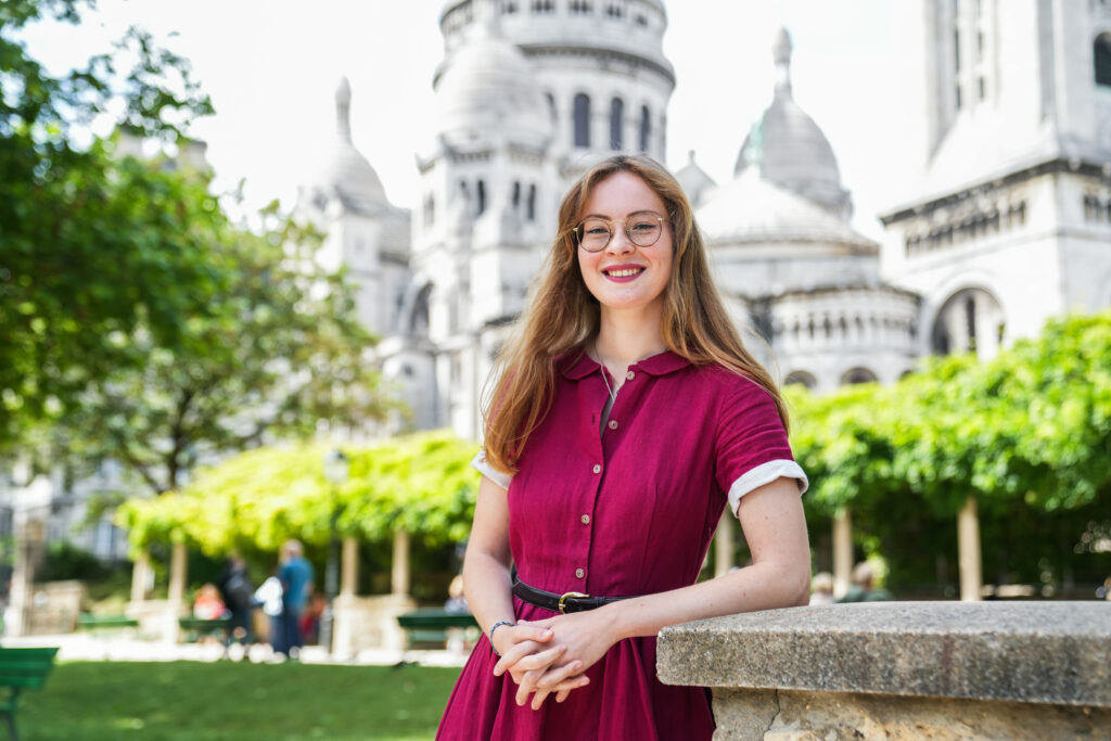 Photo de Chloé Thureau en robe rouge Son de Flor prise dans le square de la Turlure, derrière le Sacré-Coeur
